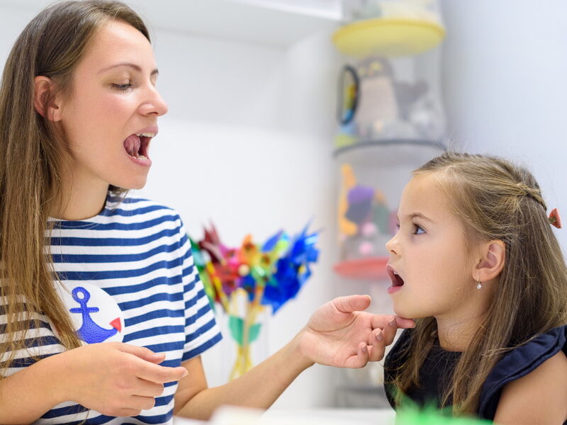 Myofunctional therapist working with a child on tongue exercises